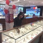 Summer Duty-Free sale in Grand Cayman at Kirk Freeport woman adjusting watch and jewelry display cases