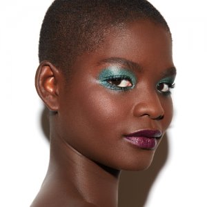 Urban Decay woman wearing deep blue eyeshadow and deep purple lipstick