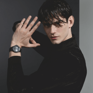 Armani stylish black watch displayed on a model holding up their arms